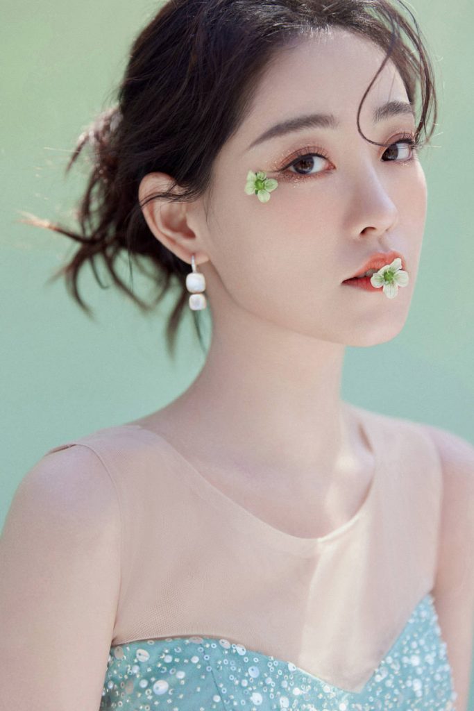 祝绪丹穿绿裙口含鲜花 妩媚动人 