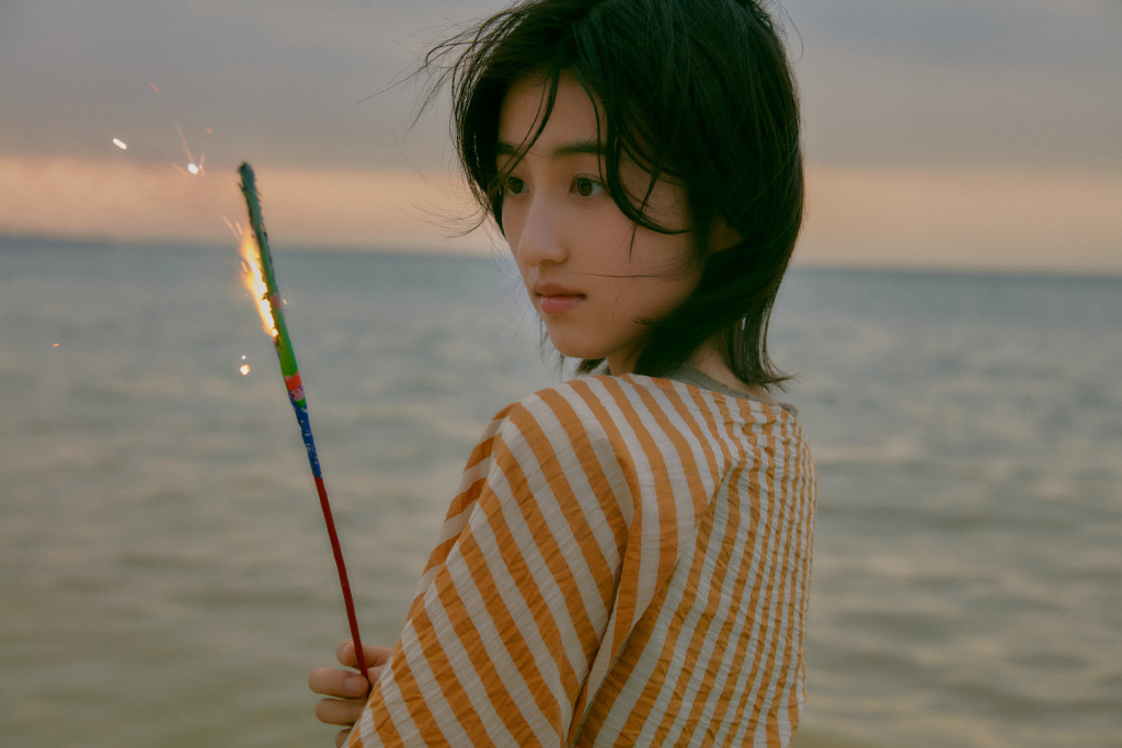 张子枫拍海边落日写真 手拿烟花笑容灿烂 
