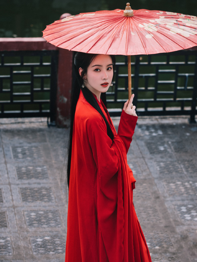 照片中,陈都灵一身红衣古装热情似火,撑伞漫步街头,美人如画!