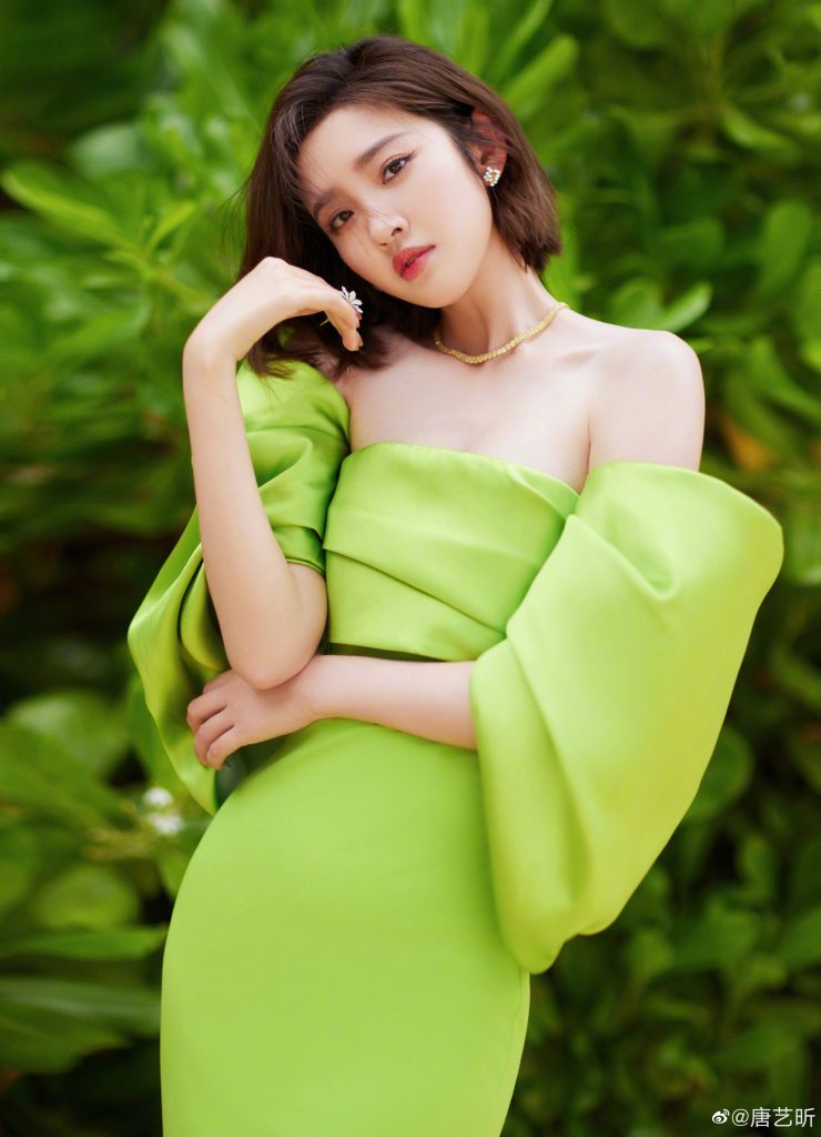 唐艺昕穿绿色抹胸裙太吸睛 坐海边秀发飞扬