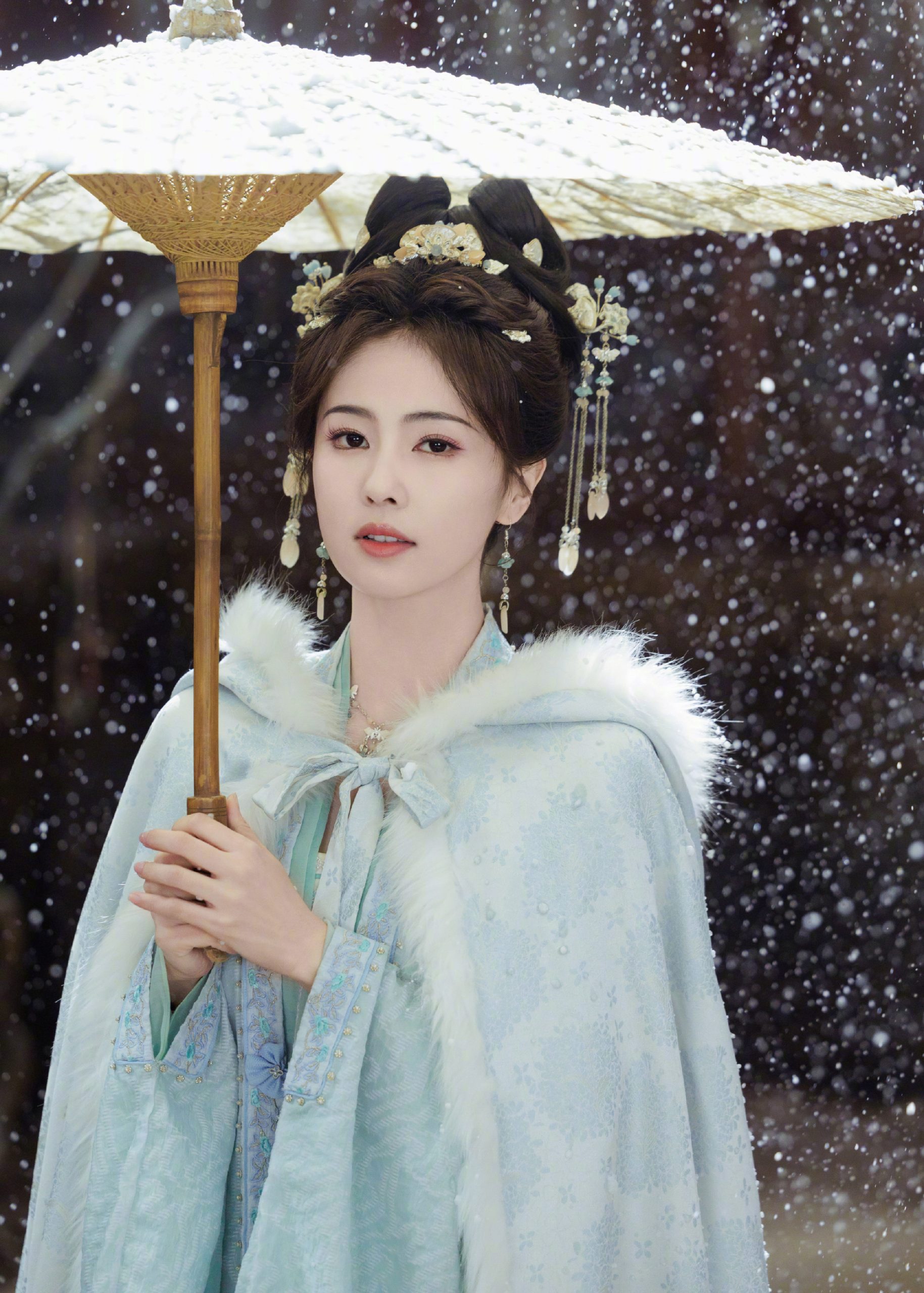 白鹿穿蓝色古装清丽动人 雪中撑伞气质温婉