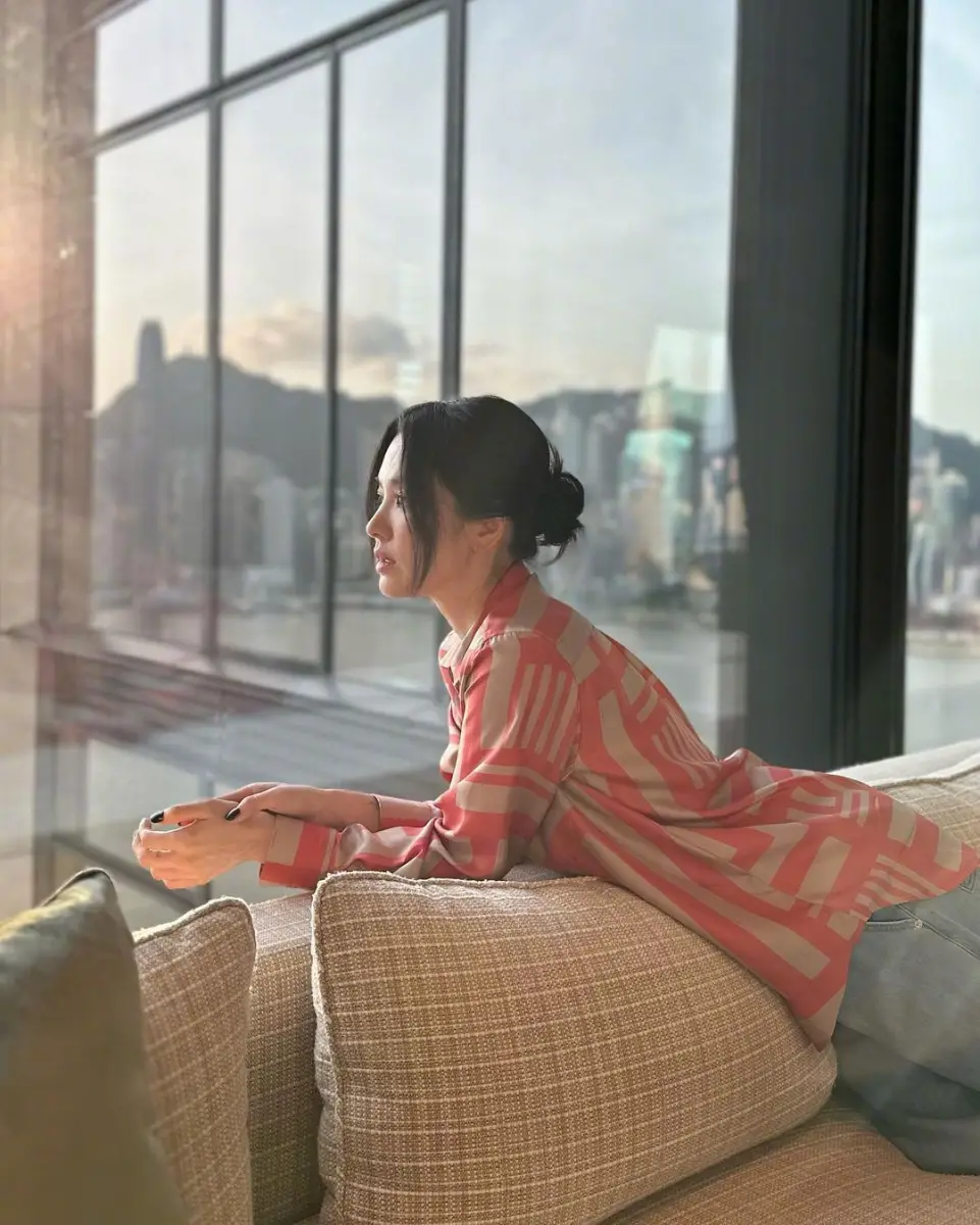 宋慧乔衬衫配牛仔裤简约美 窗边眺望维港状态松弛
