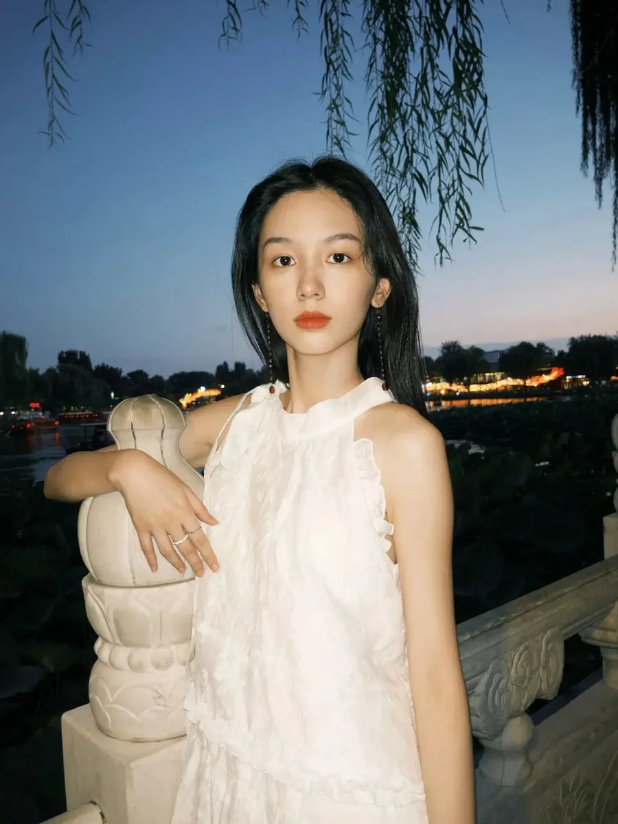 周也夏末出门遛弯赏景 穿无袖白裙秒变清冷感美女