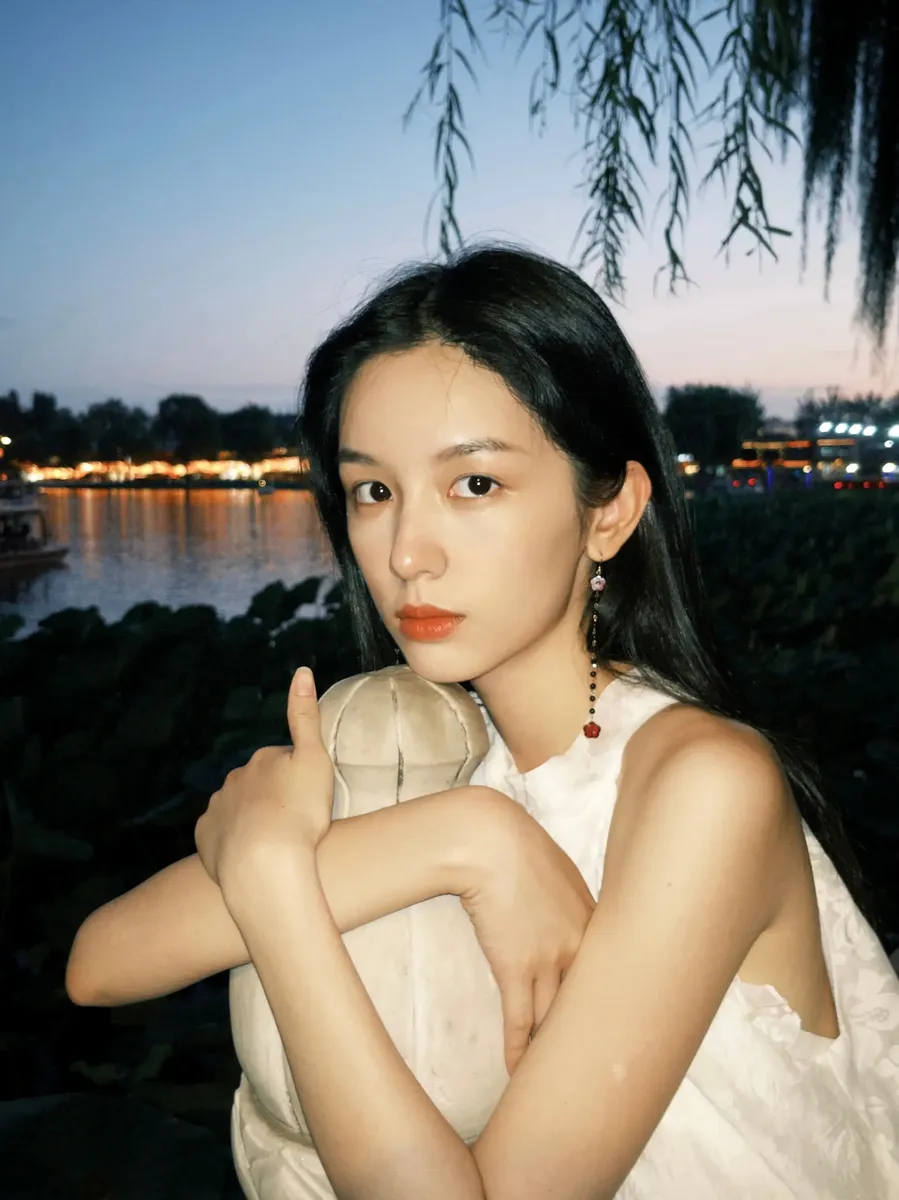 周也夏末出门遛弯赏景 穿无袖白裙秒变清冷感美女
