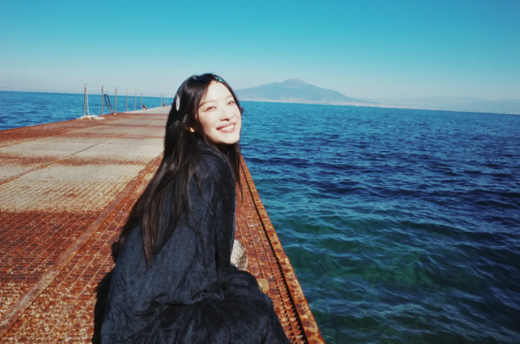 倪妮坐在岸边享受着海风的吹拂 看向远方状态松弛