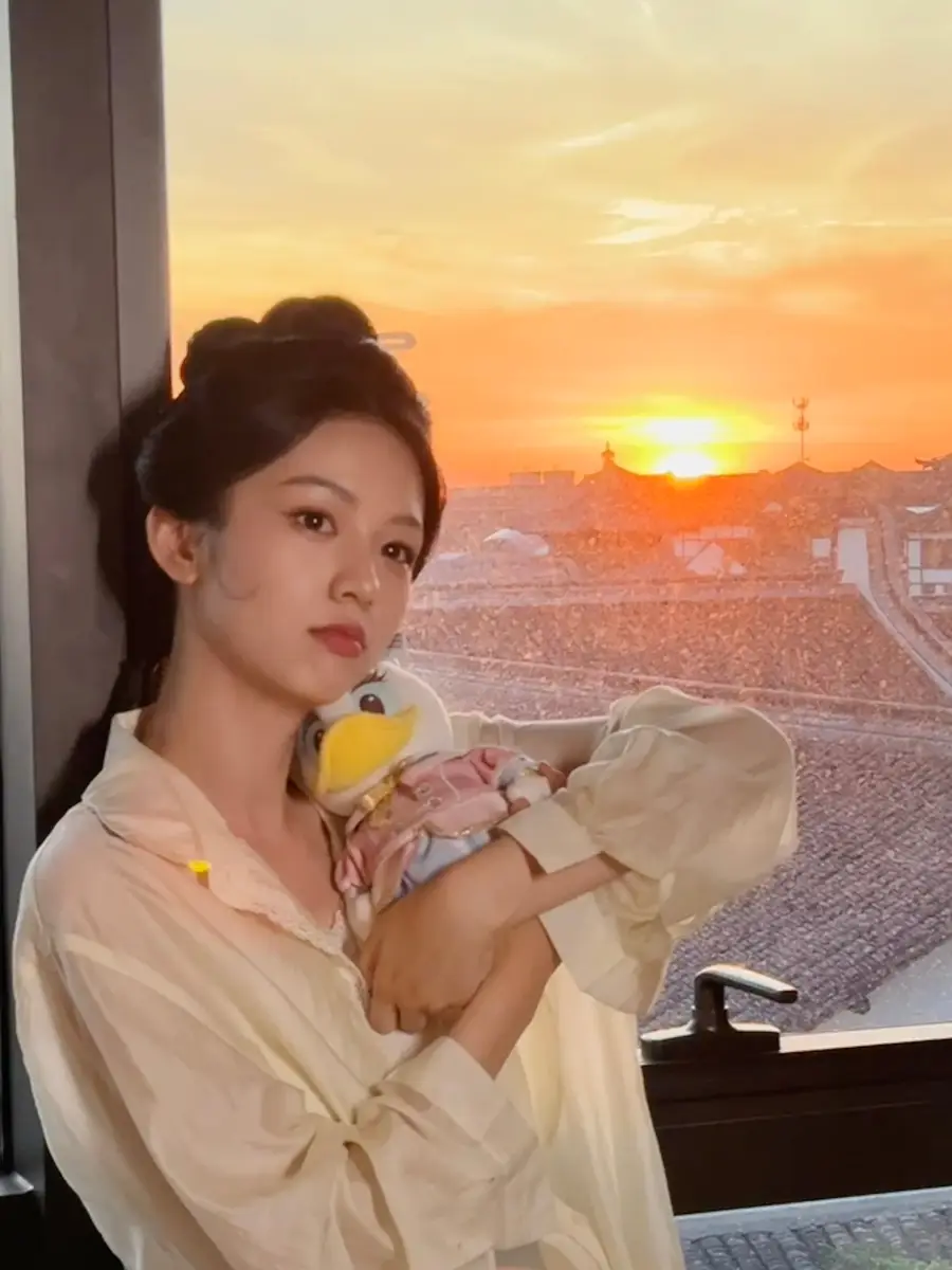 周也晒夕阳美照画面唯美动人！抱着黛丝玩偶好可爱